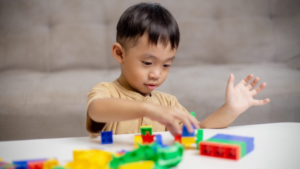 child playing with colorful toy blocks