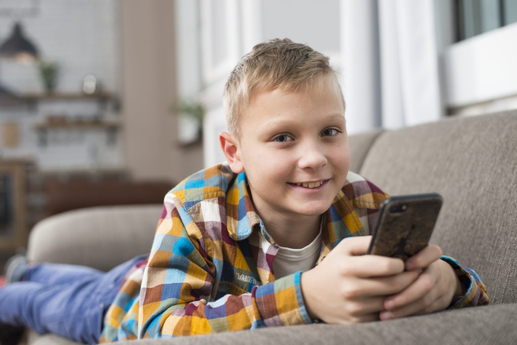 Boy smiling with working with phone