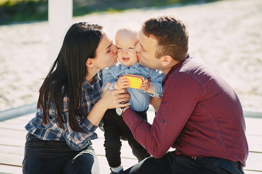 Parents kissing baby
