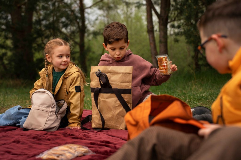 siblings sit down for a family picnic