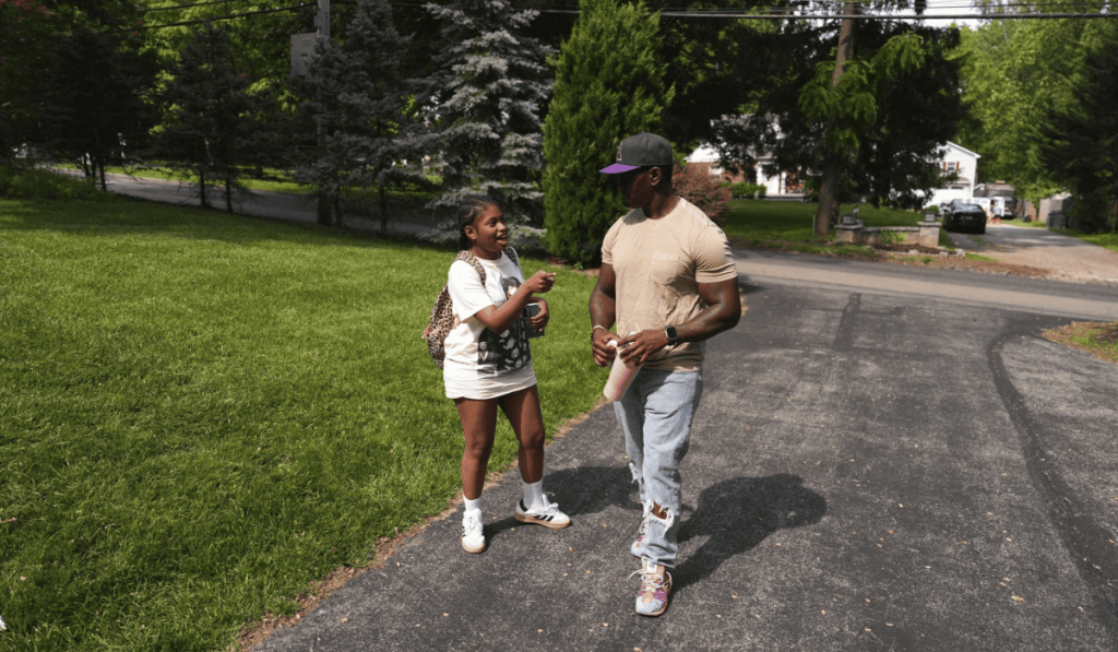 Child speaking to adult male outdoors
