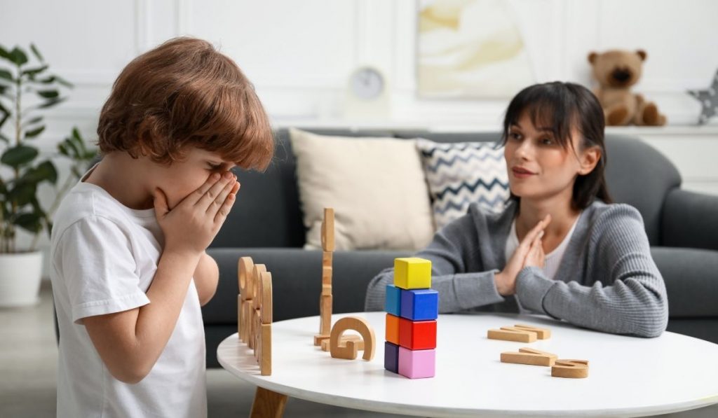 Mother watching son play with blocks