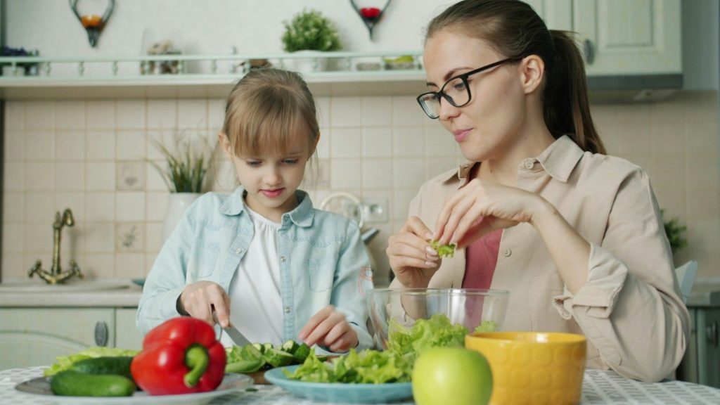 Child and mother preparing meal together