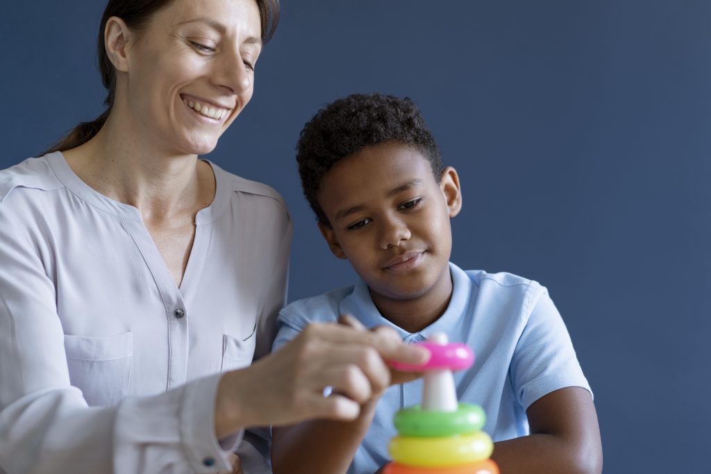 Therapist and child playing with a ring tower together