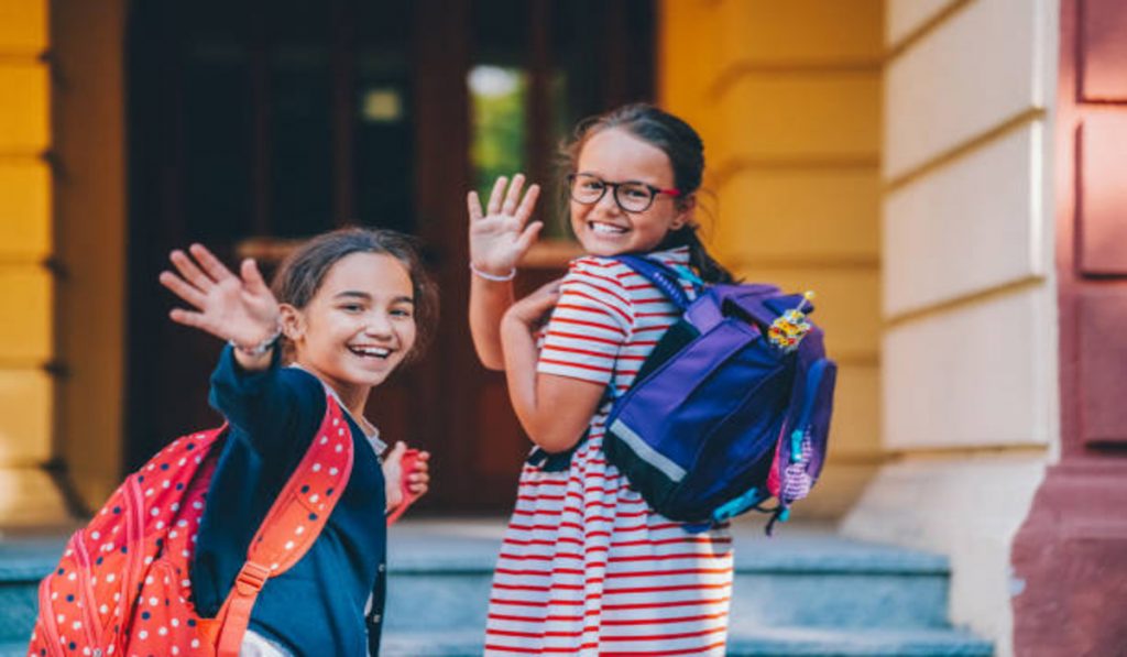 Girls heading to school with backpacks