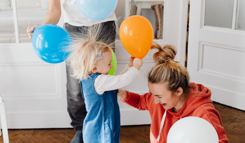 Parents playing with child and balloons