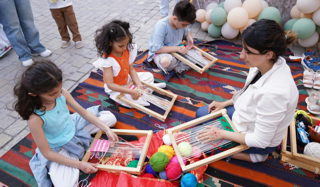 Children learning to weave