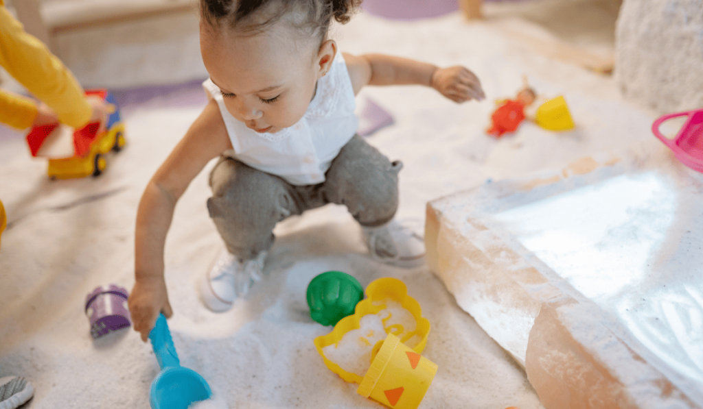 Toddler playing in sand box