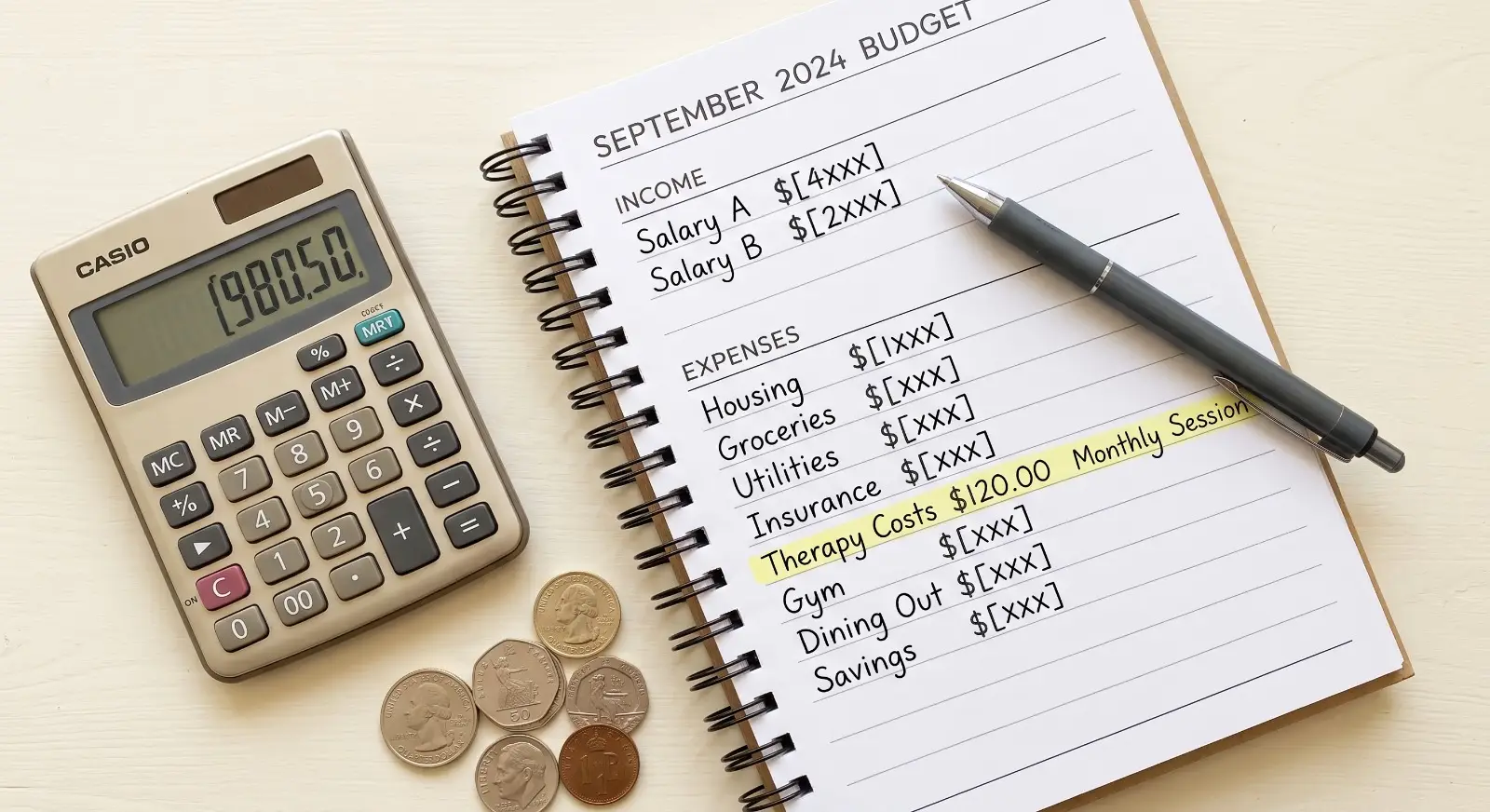 A household budget planner page with a therapy cost line item highlighted rests beside a calculator showing a running total and a small stack of coins, in a clean flat-lay composition.